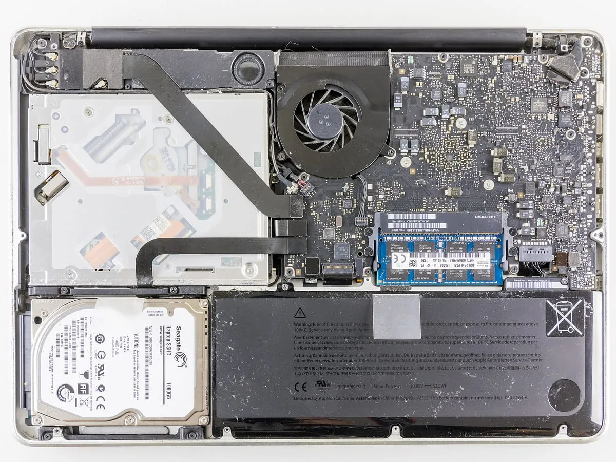 Alt kapağı açılmış MacBook Pro; batarya, disk ve fan görünüyor